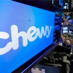 The logo for Chewy appears above trading posts on the floor of the New York Stock Exchange.