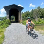 Claire Mayo of Woodbury, Vt., comes out of the Fisher Covered Bridge in Wolcott, Vt.