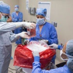 Dr. David Lott, Mayo Clinic’s chair of head and neck surgery, lifts the donor organ out of a perfusion container at Mayo Clinic Hospital in Phoenix.