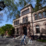 Passers-by walk past Sayles Hall on the campus of Brown University, in Providence, R.I.