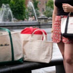 Gracie Wiener poses along side with some of her tote bags in Washington Square Park in New York, Wednesday, July 17, 2024.