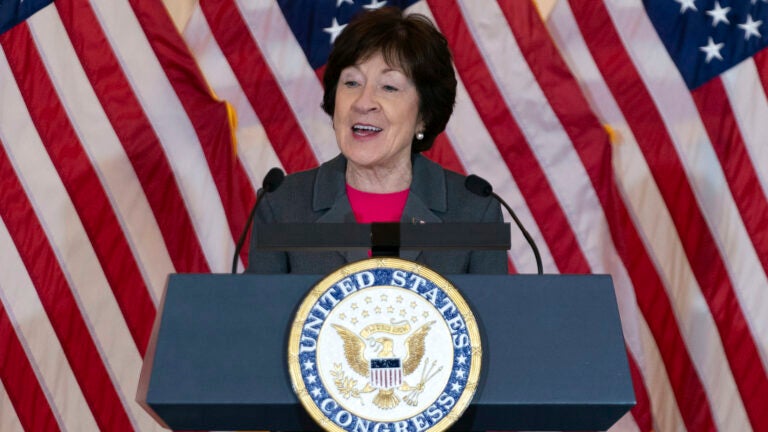 Sen. Susan Collins, R-Maine, speaks in front of American flags.