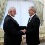 President Masoud Pezeshkian, right, shakes hands with Hamas chief Ismail Haniyeh.