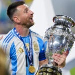 Argentina's Lionel Messi celebrates with the trophy after his team defeated Colombia in the Copa America final soccer match in Miami Gardens, Fla.