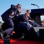 Republican presidential candidate former President Donald Trump is covered by U.S. Secret Service agents at a campaign rally, Saturday, July 13, 2024, in Butler, Pa.