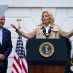 President Joe Biden listens as first lady Jill Biden speaks during a barbecue with active-duty military service members and their families on the South Lawn of the White House, Thursday, July 4, 2024, in Washington.