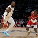 United States' forward LeBron James, left, and Germany's guard Dennis Schroeder challenge for the ball during an exhibition basketball game between the United States and Germany at the O2 Arena in London.