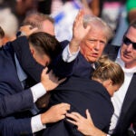 Republican presidential candidate former President Donald Trump is helped off the stage by U.S. Secret Service agents at a campaign event in Butler, Pa., on Saturday, July 13, 2024.