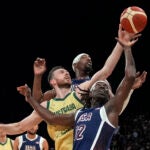 Australia's Nick Kay, front left, fights for the ball with United States' Jrue Holiday (12) and Bam Adebayo, back right, during the USA Basketball Showcase in Abu Dhabi, United Arab Emirates.