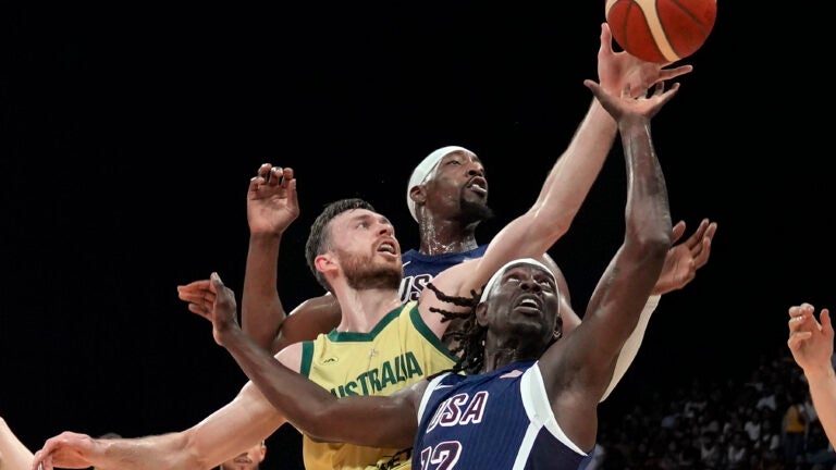 Australia's Nick Kay, front left, fights for the ball with United States' Jrue Holiday (12) and Bam Adebayo, back right, during the USA Basketball Showcase in Abu Dhabi, United Arab Emirates.