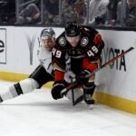 LOS ANGELES, CALIFORNIA - FEBRUARY 24: Max Jones #49 of the Anaheim Ducks and Trevor Lewis #61 of the Los Angeles Kings react as they move to the puck along the boards during a 3-2 Kings overtime shootout win at Crypto.com Arena on February 24, 2024 in Los Angeles, California.