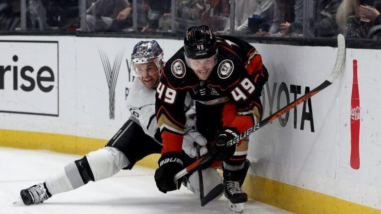 LOS ANGELES, CALIFORNIA - FEBRUARY 24: Max Jones #49 of the Anaheim Ducks and Trevor Lewis #61 of the Los Angeles Kings react as they move to the puck along the boards during a 3-2 Kings overtime shootout win at Crypto.com Arena on February 24, 2024 in Los Angeles, California.