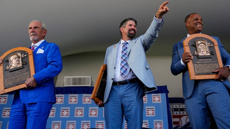 Baseball Hall of Fame inductees Jim Leyland, left, Todd Helton, center, and Adrián Beltré, right, holds their plaques at the National Baseball Hall of Fame induction ceremony.