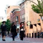 People walk through Essex street in downtown Salem.