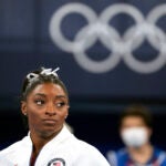 In this July 27, 2021 file photo, Simone Biles, of the United States, watches gymnasts perform after she exited the team final at the 2020 Summer Olympics, in Tokyo.