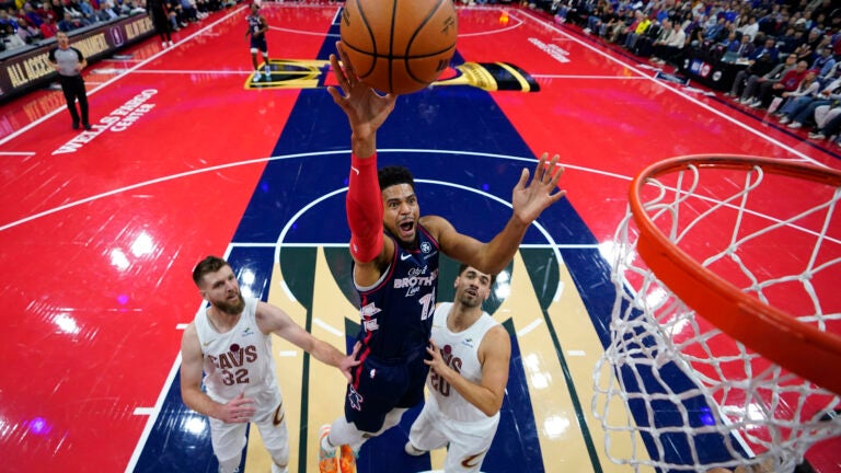 Philadelphia 76ers' Tobias Harris, center, goes up for a shot between Cleveland Cavaliers' Dean Wade, left, and Georges Niang during the first half of an NBA basketball in-season tournament game.