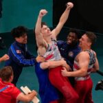 Stephen Nedorscik of the United States is congratulated after the pommel horse during the men's artistic gymnastics team finals at the 2024 Summer Olympics.