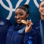 From left to right, Suni Lee, Simone Biles, Hezly Rivera celebrate after winning the gold medal during the women's artistic gymnastics team finals round at Bercy Arena at the 2024 Summer Olympics, Tuesday, July 30, 2024, in Paris, France.