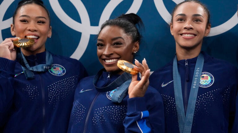 From left to right, Suni Lee, Simone Biles, Hezly Rivera celebrate after winning the gold medal during the women's artistic gymnastics team finals round at Bercy Arena at the 2024 Summer Olympics, Tuesday, July 30, 2024, in Paris, France.