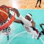 Bam Adebayo, of the United States, puts in a basket in front of Peter Jok, of South Sudan, in a men's basketball game at the 2024 Summer Olympics.