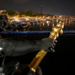 Technicians remove the pontoon for the start of the triathlon events after the event was postponed over concerns about water quality in Paris' Seine River.