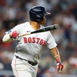 Rafael Devers of the Red Sox tosses his bat after hitting a home run against the New York Yankees during seventh inning.