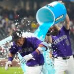 Colorado Rockies' Charlie Blackmon, back, douses Ezequiel Tovar after his walkoff RBI single off Boston Red Sox relief pitcher Chase Anderson in the 12th inning of a baseball game Monday, July 22, 2024, in Denver.