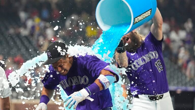 Colorado Rockies' Charlie Blackmon, back, douses Ezequiel Tovar after his walkoff RBI single off Boston Red Sox relief pitcher Chase Anderson in the 12th inning of a baseball game Monday, July 22, 2024, in Denver.