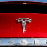 FILE - The Tesla logo appears on an unsold 2020 Model X at a dealership, Feb. 2, 2020, in Littleton, Colo.
