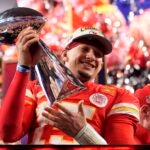 Kansas City Chiefs quarterback Patrick Mahomes celebrates with the trophy after the team's win in overtime during the NFL Super Bowl 58 football game against the San Francisco 49ers.