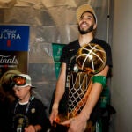 Boston Celtics forward Jayson Tatum holds the Larry O'Brien championship trophy in the locker room with his son Deuce after winning the 2024 NBA Finals over the Dallas Mavericks at TD Garden on Monday, June 17, 2024.