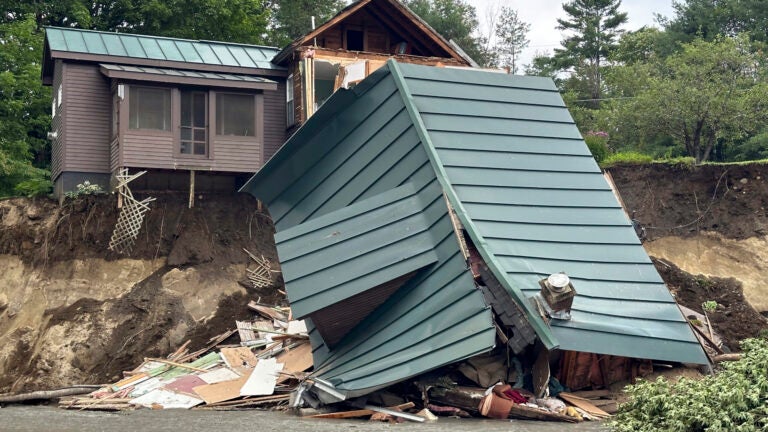 Trees and debris sit next to a damaged home after flooding in Lyndonville, Vt., Tuesday, July 30, 2024.