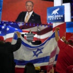 People hold an Israeli flag as Matt Brooks, chief executive of the Republican Jewish Coalition, speaks on the second night of the Republican National Convention.