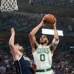 Boston Celtics forward Jayson Tatum (0) drives against Dallas Mavericks guard Luka Doncic (77) during the first quarter in Game 3 of the NBA Finals. The Dallas Mavericks hosted the Boston Celtics at American Airlines Center on Wednesday, June 12, 2024.