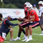 Quarterbacks Drake Maye (R) and Jacoby Brissett look to pass during Patriots practice at Gillette Stadium.