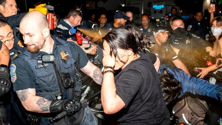 Officers of the Metropolitan Police Department pepper spray demonstrators at George Washington University in Washington.