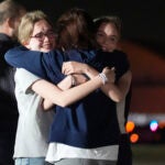 Alsu Kurmasheva, center, hugs her daughters Miriam Butorin, left, and Bibi Butorin at Andrews Air Force Base, Md.