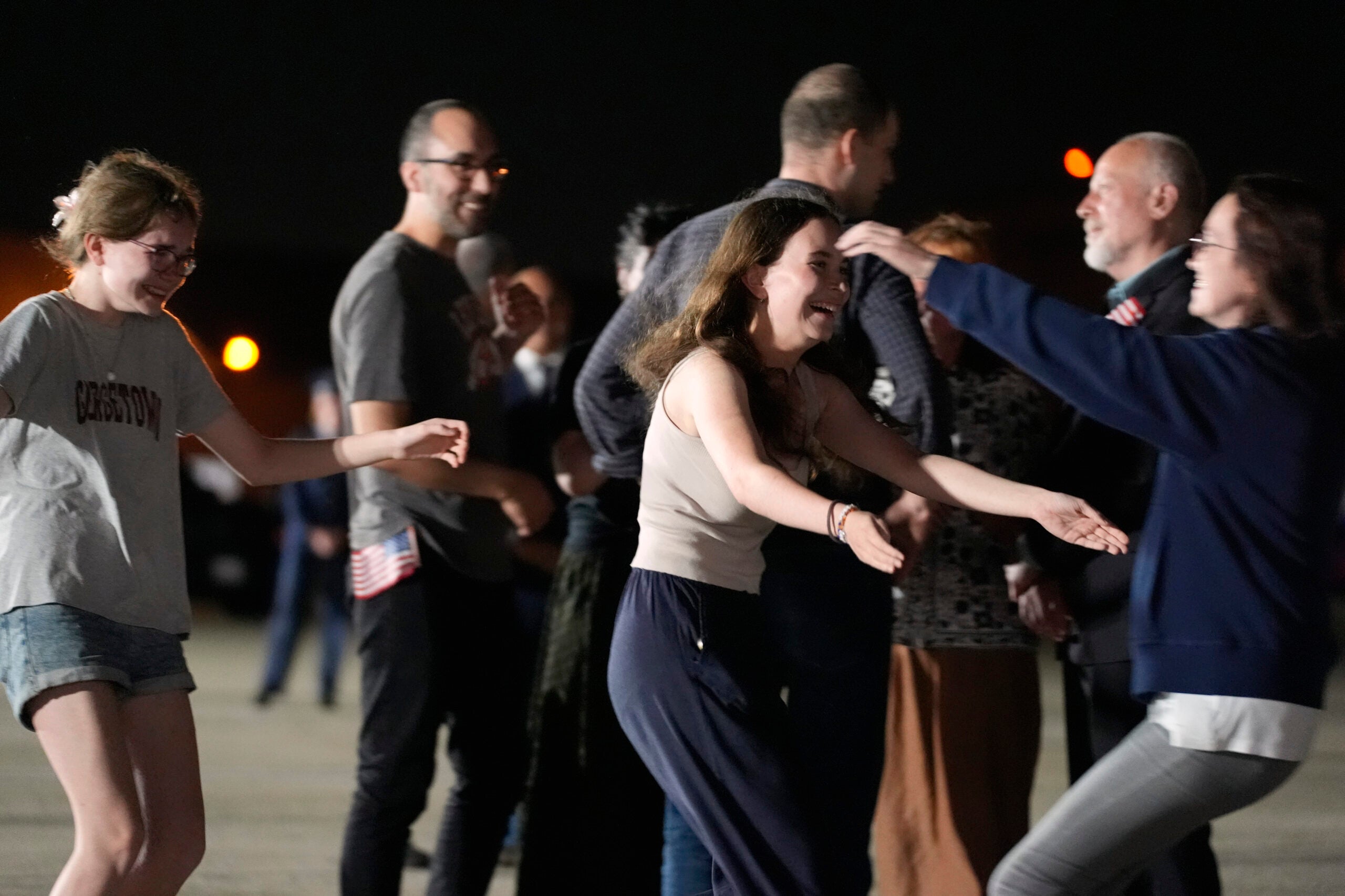Miriam Butorin, from left, and Bibi Butorin, daughters of Alsu Kurmasheva, run to hug their mother at Andrews Air Force Base, Md.