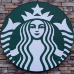 A Starbucks mermaid logo sign is displayed on a store.
