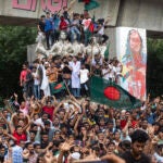 Protesters climb a public monument as they celebrate the news of Prime Minister Sheikh Hasina's resignation, in Dhaka, Bangladesh, Monday, Aug. 5, 2024.