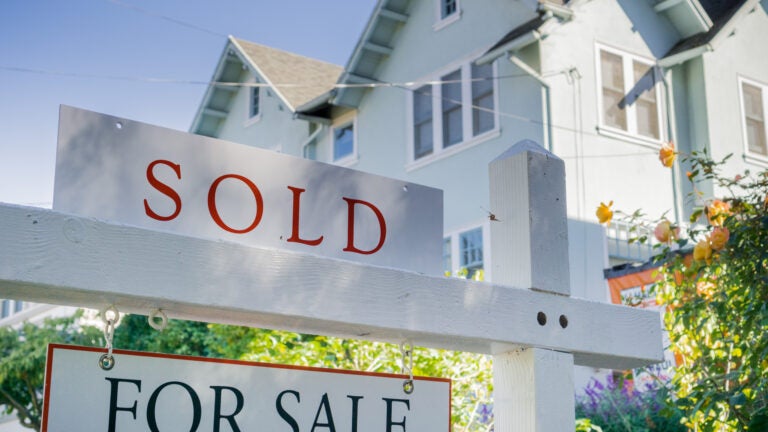 Sold sign in front of a house in a residential neighborhood, California commissions