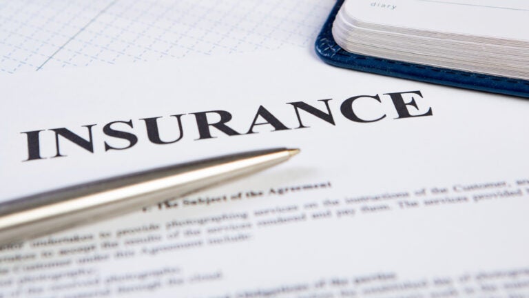 Closeup the silver ballpoint modern pen on insurance contract with planning in background.