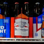 Six-packs of Bud Light, Budweiser and Michelob Ultra are displayed at a liquor store.