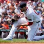 Boston Red Sox starting pitcher James Paxton grabs his leg during the first inning of a baseball game against the Houston Astros, Sunday, Aug. 11, 2024, in Boston.