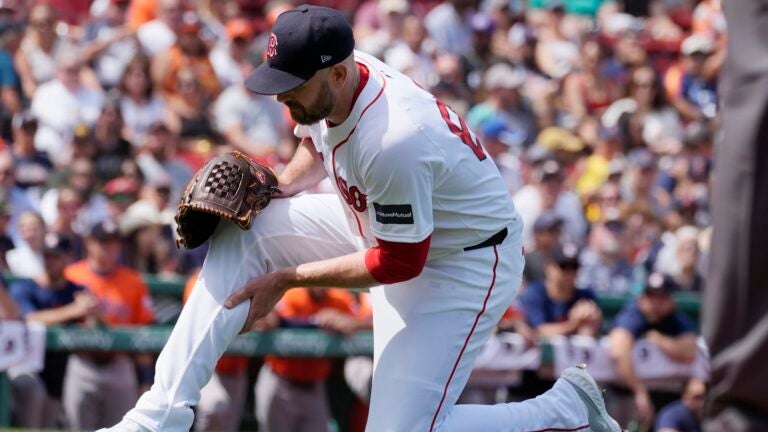 Boston Red Sox starting pitcher James Paxton grabs his leg during the first inning of a baseball game against the Houston Astros, Sunday, Aug. 11, 2024, in Boston.