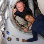 In this photo provided by NASA, Boeing Crew Flight Test astronauts Butch Wilmore, left, and Suni Williams pose for a portrait inside the vestibule between the forward port on the International Space Station's Harmony module and Boeing's Starliner spacecraft on June 13, 2024.