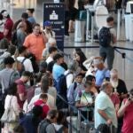 Passengers wait in line for assistance at the Delta Terminal, July 19, 2024, at Logan International Airport in Boston.