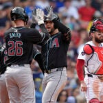 Arizona Diamondbacks' Eugenio Suárez, center, celebrates after his three-run home run with Pavin Smith, left, near Red Sox catcher Connor Wong, right, in the sixth inning.