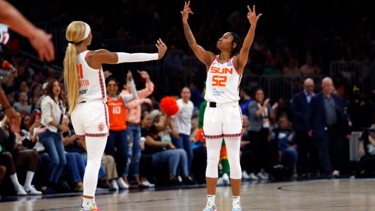 Connecticut Sun guard Tyasha Harris (52) reacts with guard DiJonai Carrington (21) after Harris hits a three-point basket to end the first half at TD Garden.