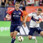 New England Revolution midfielder Noel Buck (29) and Vancouver Whitecaps midfielder Ryan Gauld (25) chase the ball during the second half of an MLS soccer match.